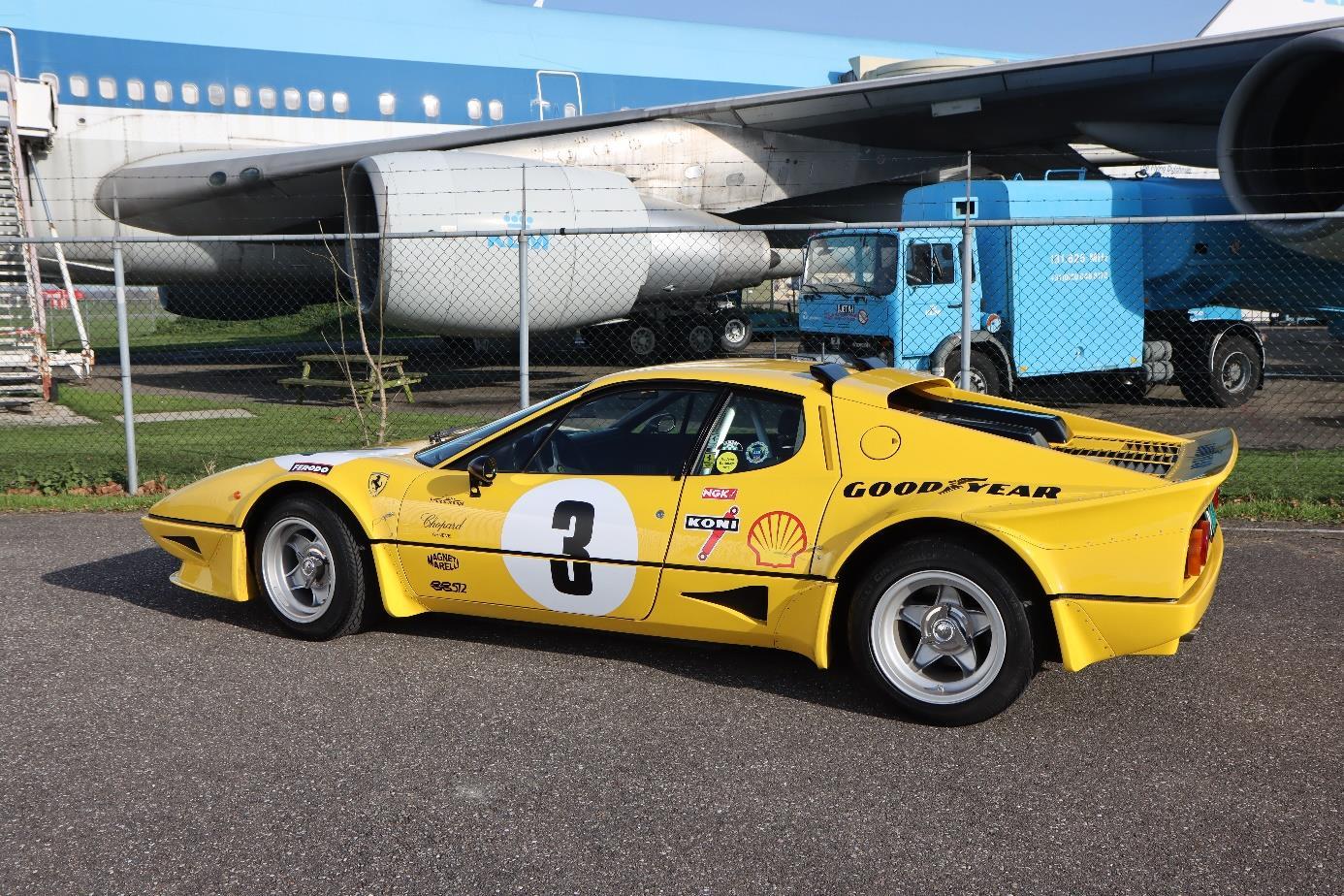 Modified yellow Ferrari 512 BB from the rear quarter, showing the extended tail and raised rear spoiler.